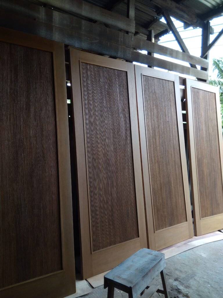 Pintu kayu jati solid minimalis dengan serat alami hasil produksi workshop PK Tunas Kayu Jakarta.